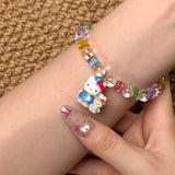Angled studio product view of Rainbow Friends Crystal Charm Bracelet on a white jewelry display against a black background.