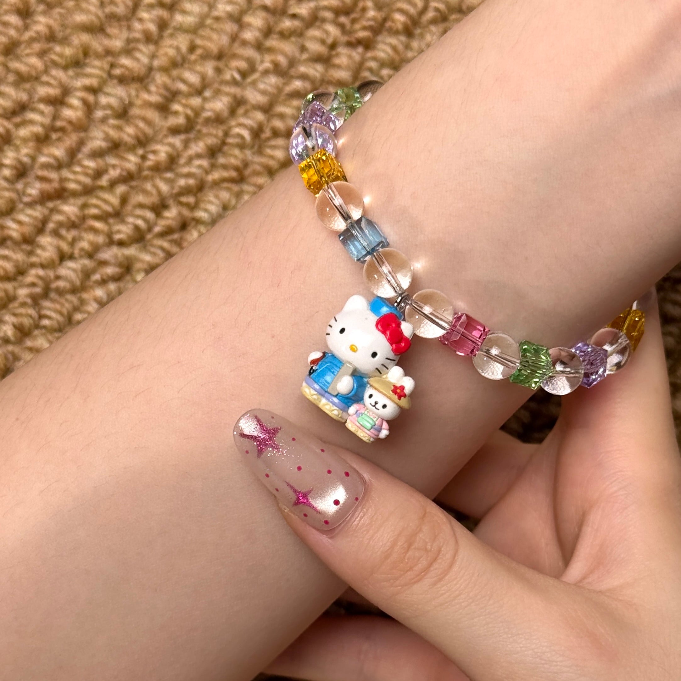 Angled studio product view of Rainbow Friends Crystal Charm Bracelet on a white jewelry display against a black background.