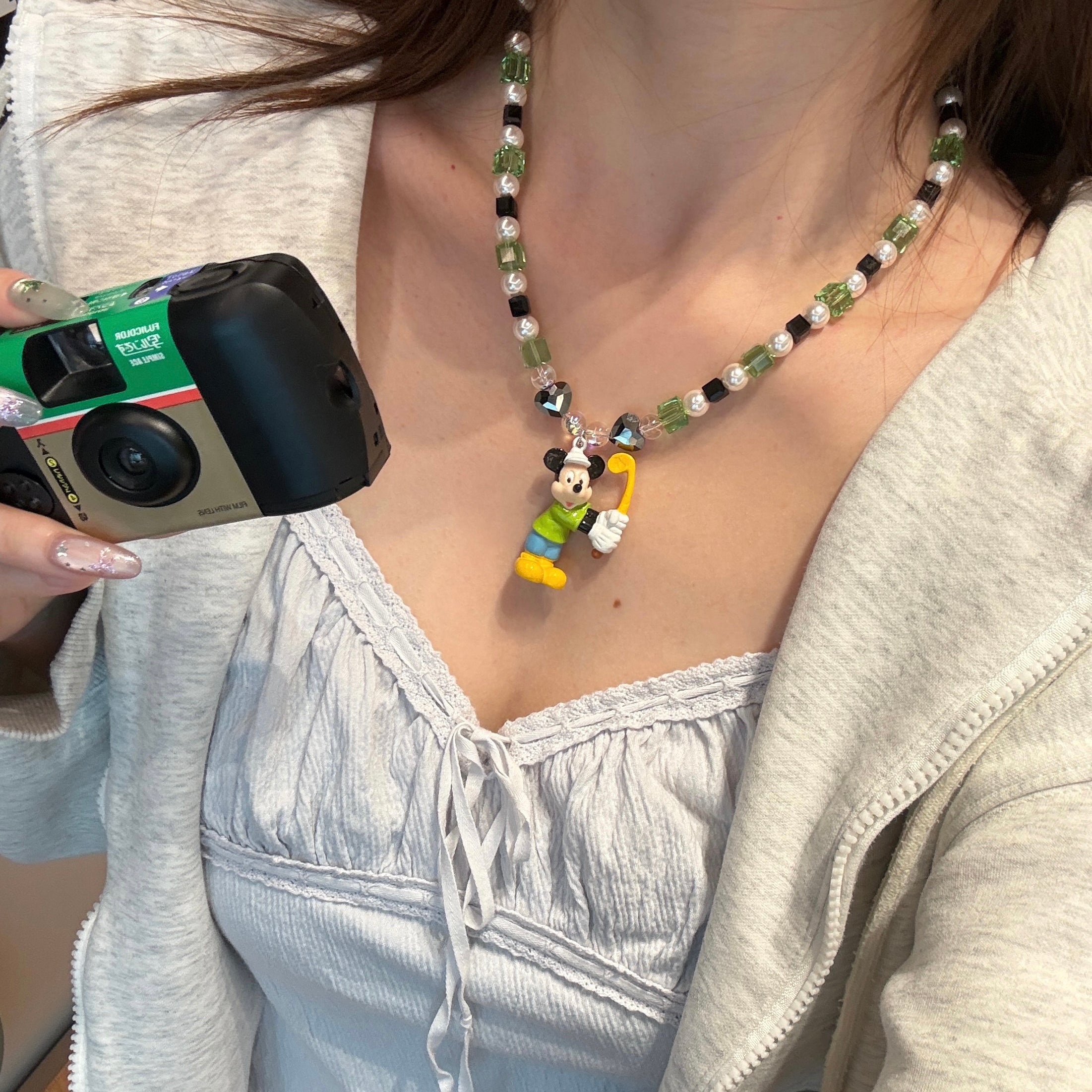 Close-up product image of Emerald Quest Crystal Charm Necklace featuring green cubes, black accents and mouse golfer charm.