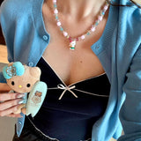 Additional product detail image of Lilac Bloom Crystal Charm Necklace featuring lilac cube crystals, iridescent beads and white cat charm.