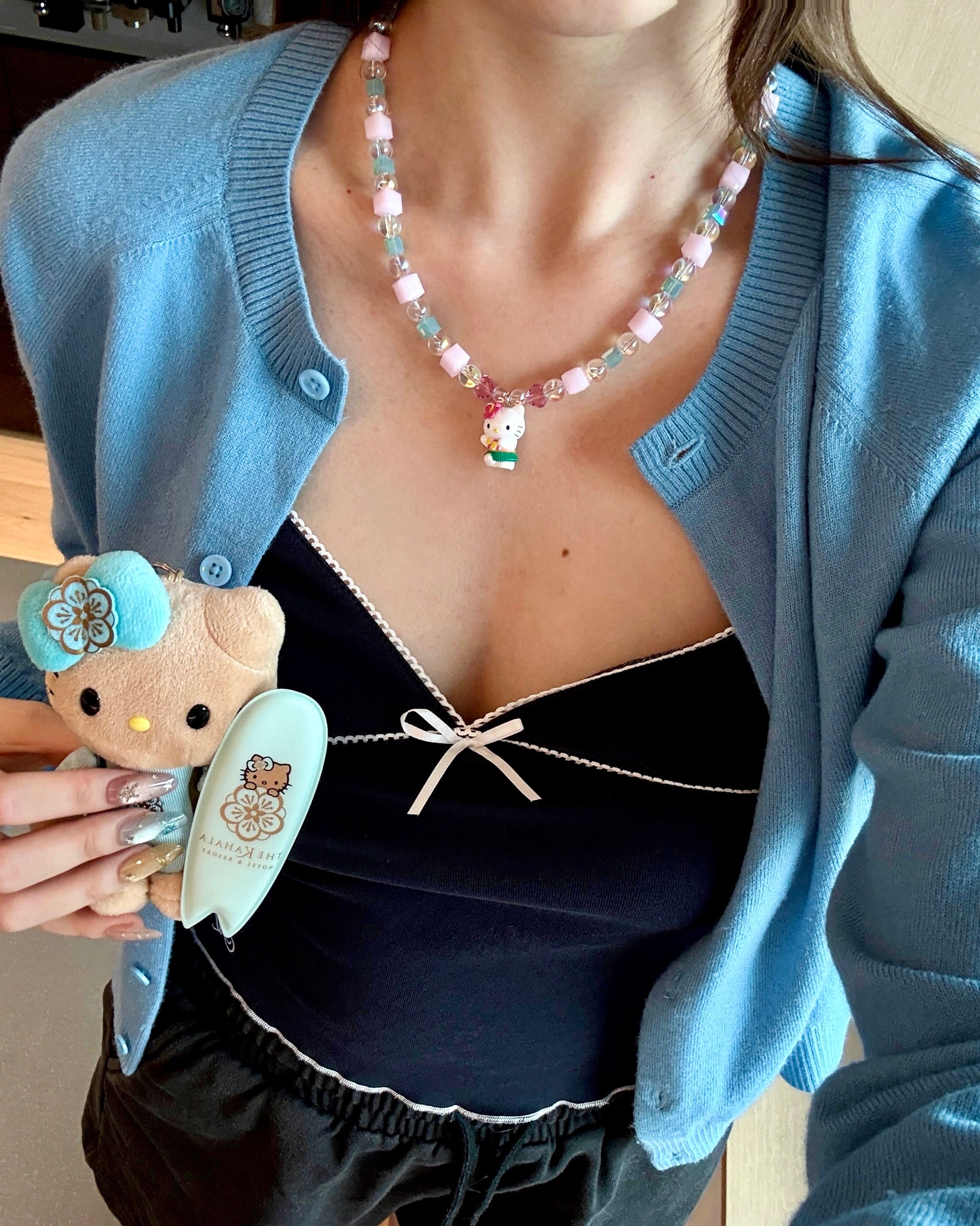 Additional product detail image of Lilac Bloom Crystal Charm Necklace featuring lilac cube crystals, iridescent beads and white cat charm.