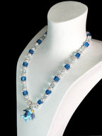 Model wearing handmade blue crystal charm necklace with Swarovski cube beads and pearls