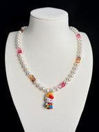 Model wearing handmade pink crystal charm necklace with amber Swarovski beads and pearls