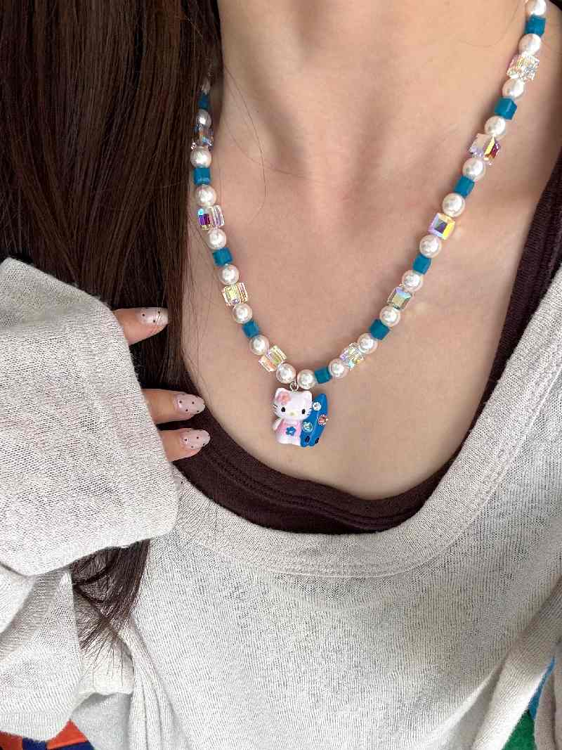 Teal blue Swarovski crystal beads close-up on handmade pearl charm necklace by ShinoraStudio