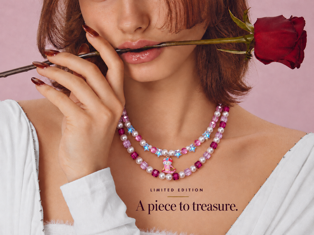 Limited Edition: A piece to treasure. Woman holding a red rose and wearing a pink double-layer crystal charm necklace.