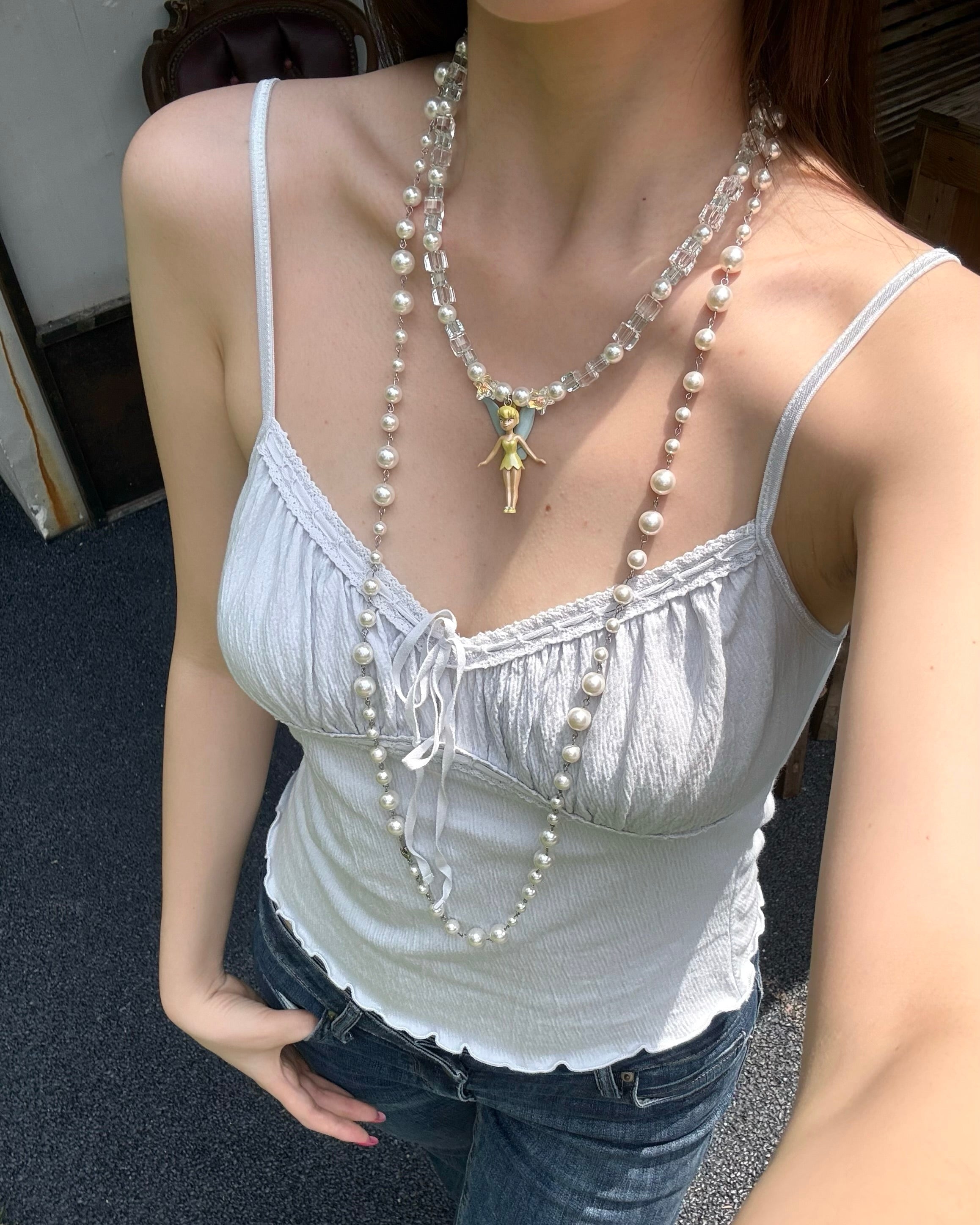 Model wearing a handmade blue Swarovski crystal charm necklace with pearls and vintage-inspired charm details.