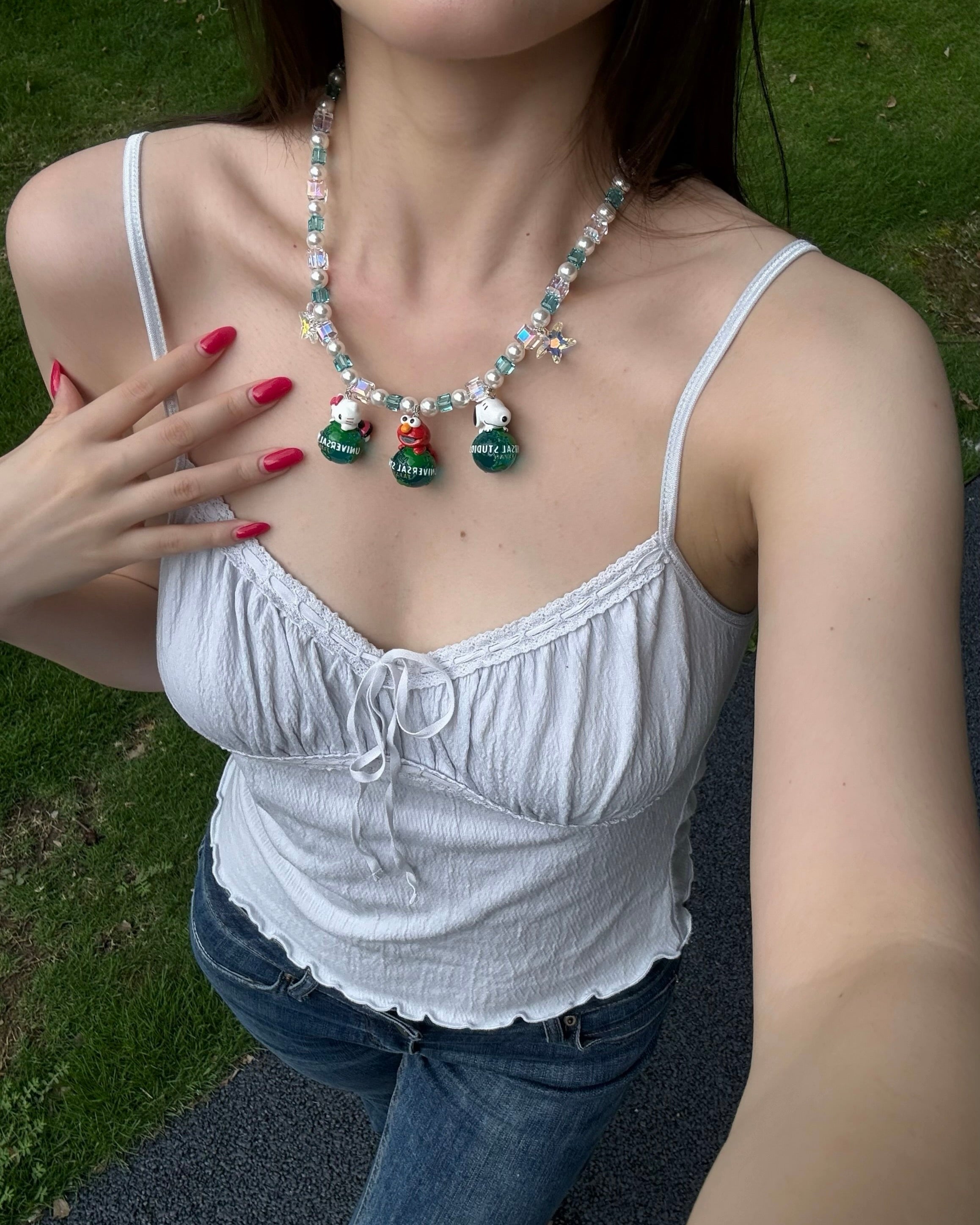 Model wearing a handmade colorful Swarovski crystal charm necklace with pearls and vintage-inspired charm details.