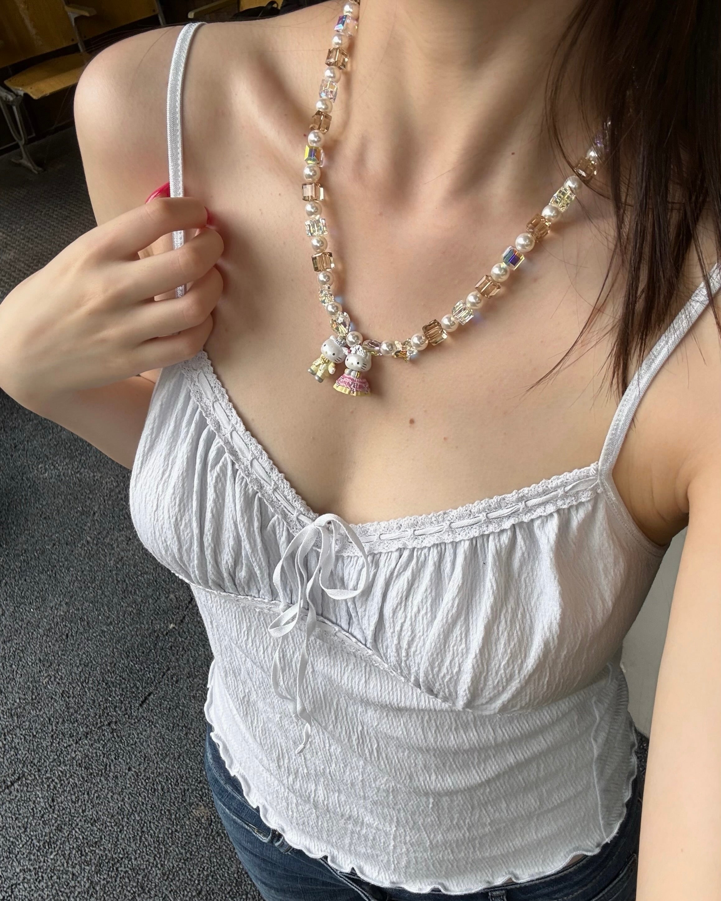 Model wearing a handmade colorful Swarovski crystal charm necklace with pearls and vintage-inspired charm details.