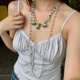 Model wearing a handmade colorful Swarovski crystal charm necklace with pearls and vintage-inspired charm details.