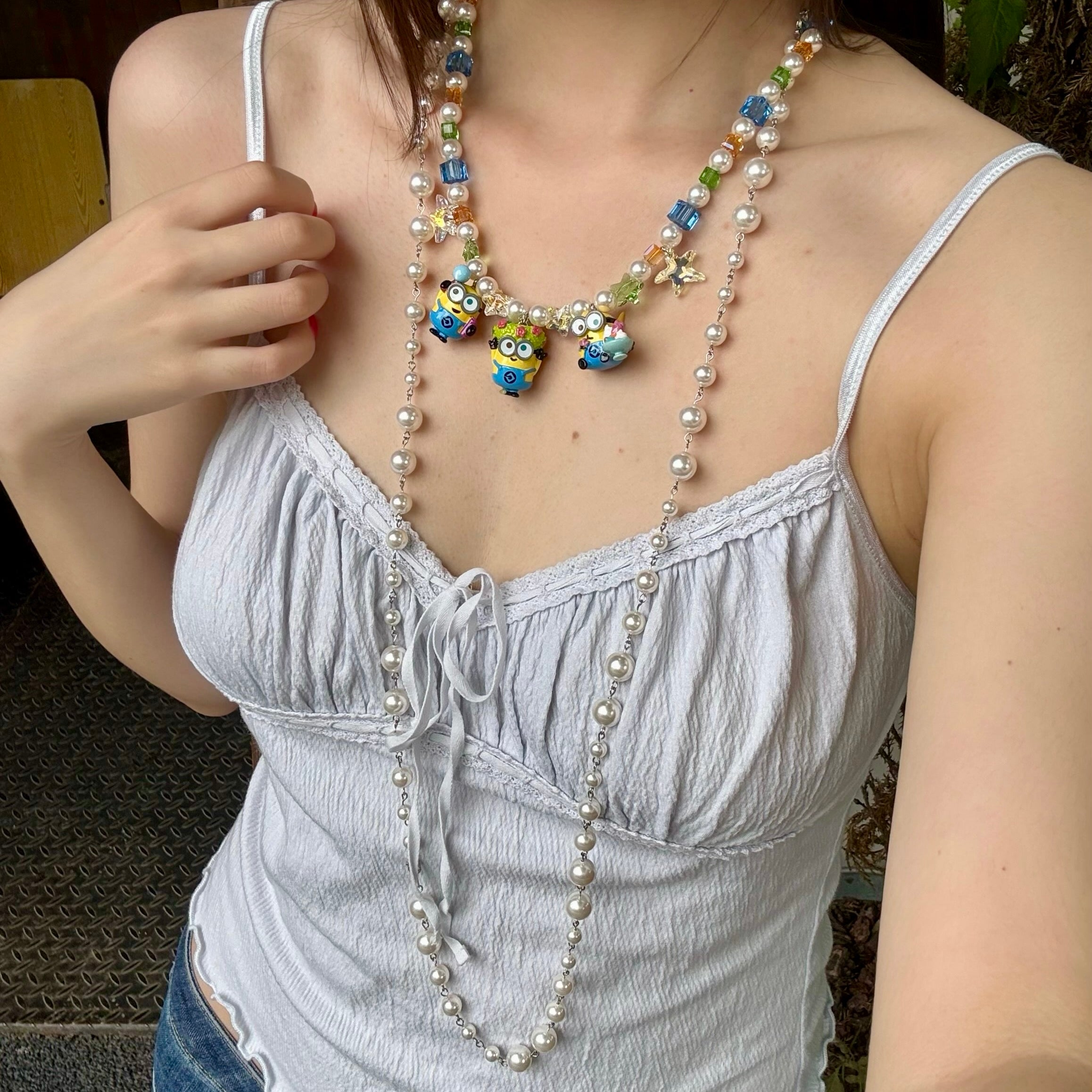 Model wearing a handmade colorful Swarovski crystal charm necklace with pearls and vintage-inspired charm details.