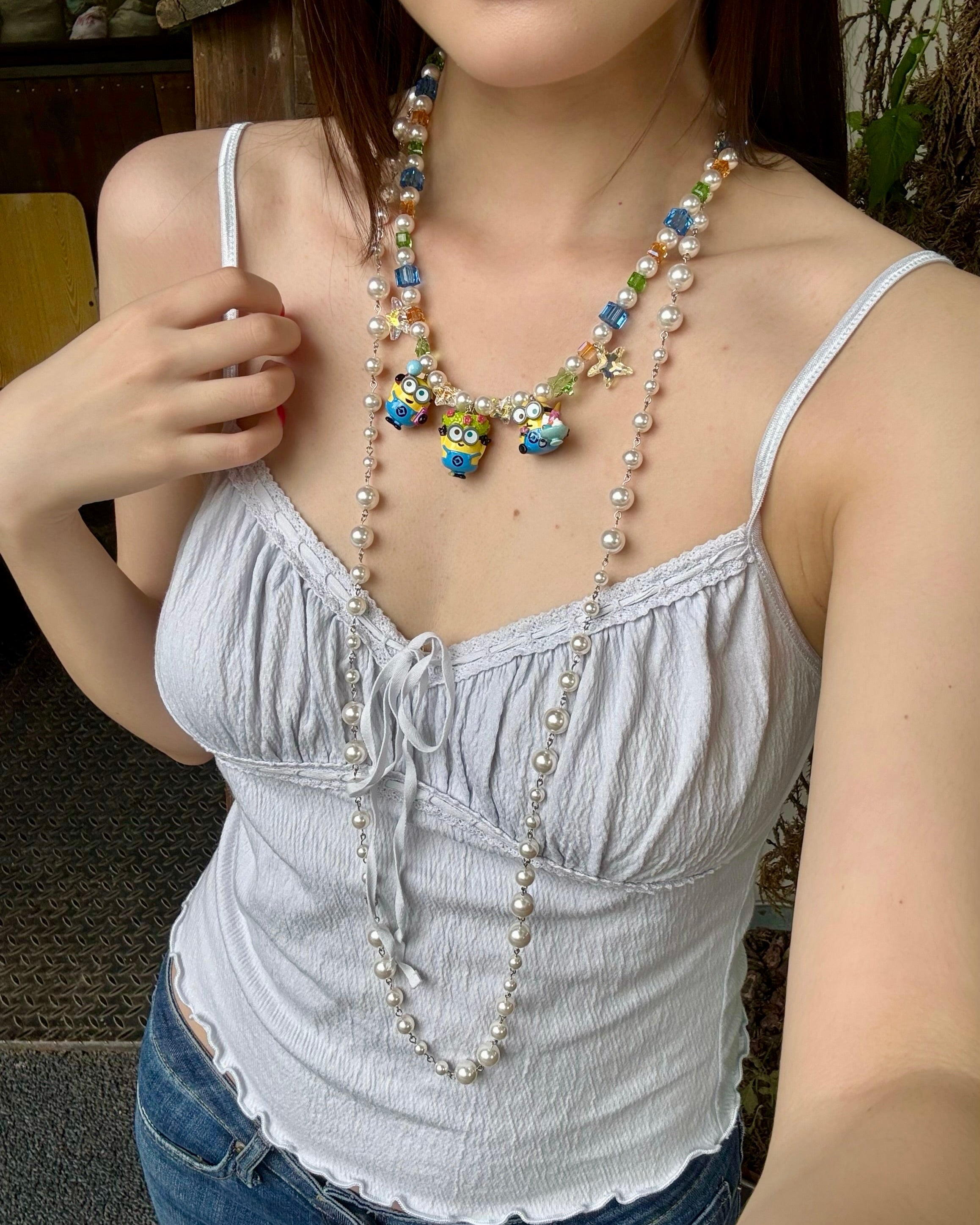 Model wearing a handmade colorful Swarovski crystal charm necklace with pearls and vintage-inspired charm details.