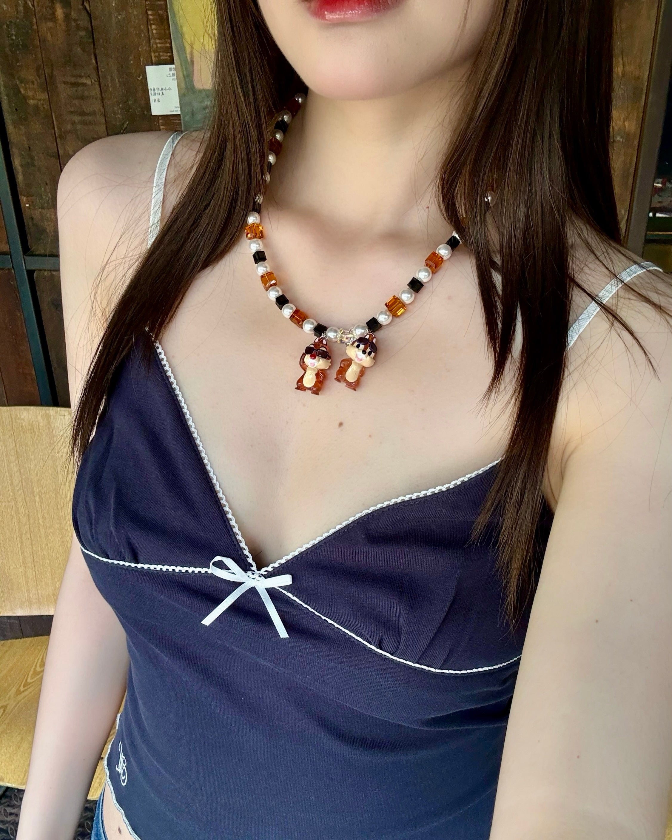Model wearing a handmade colorful Swarovski crystal charm necklace with pearls and vintage-inspired charm details.