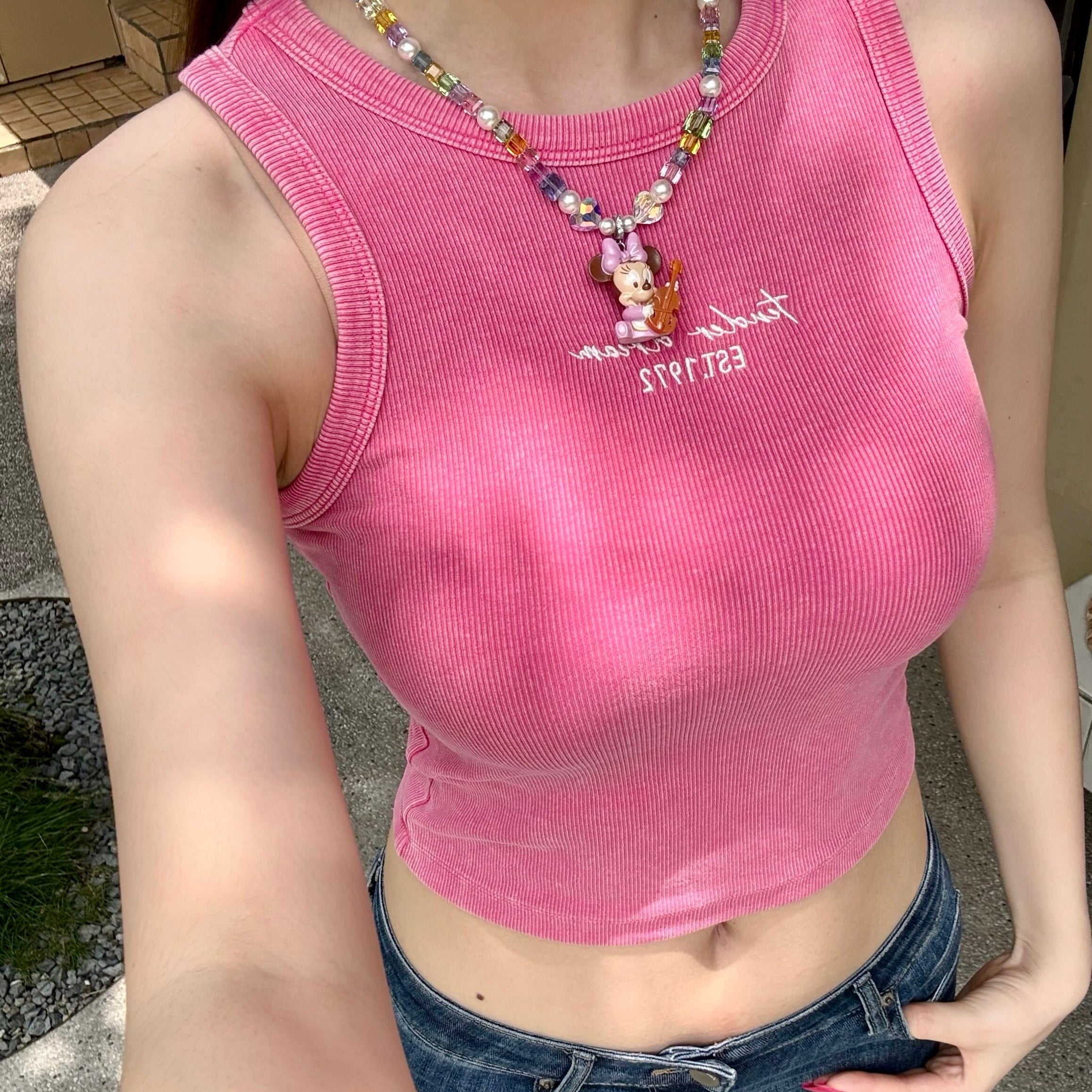 Model wearing a handmade rainbow Swarovski crystal charm necklace with pearls and vintage-inspired charm details.