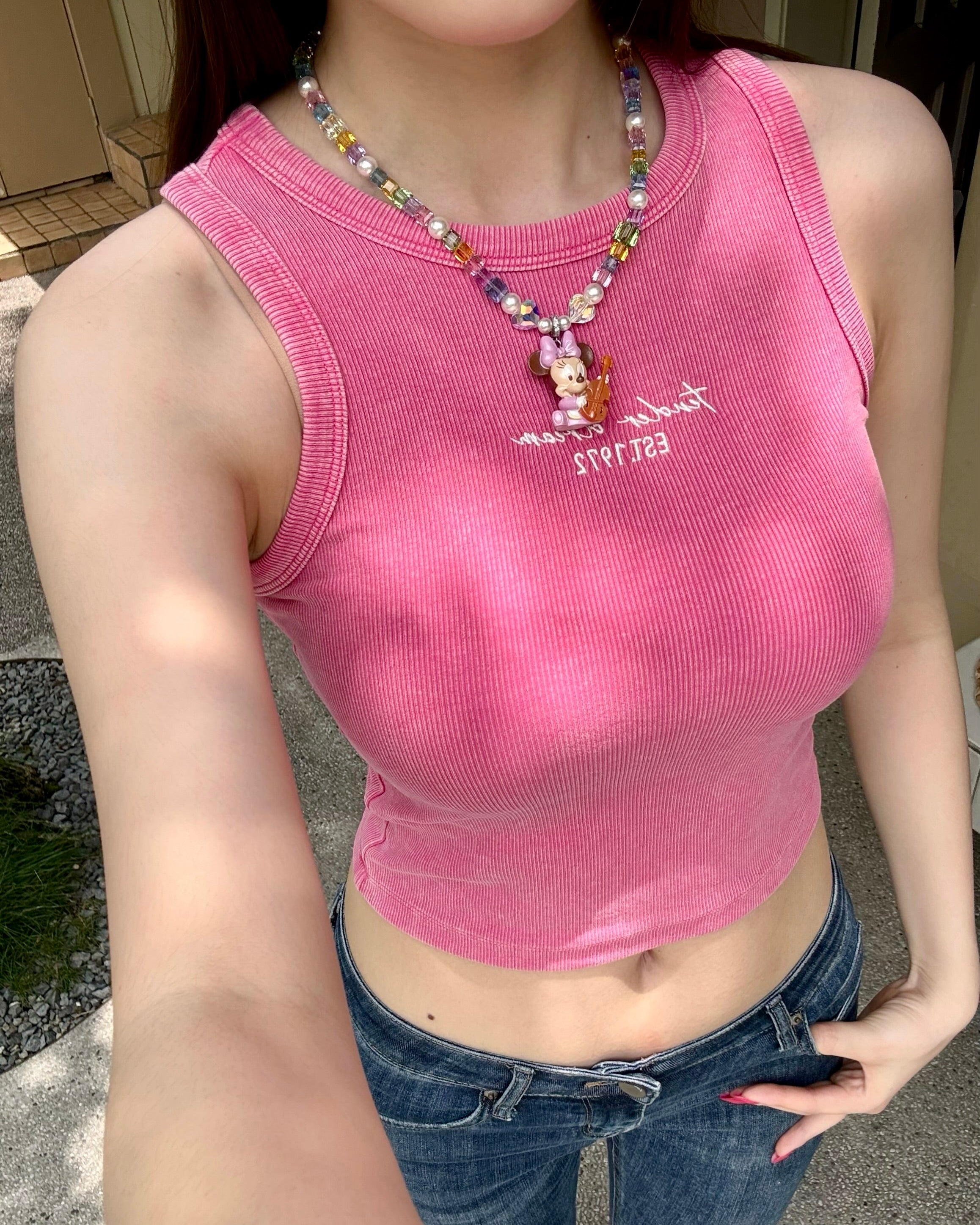 Model wearing a handmade rainbow Swarovski crystal charm necklace with pearls and vintage-inspired charm details.