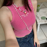 Model wearing a handmade red heart charm necklace with white Swarovski crystal pearls and iridescent cube beads.