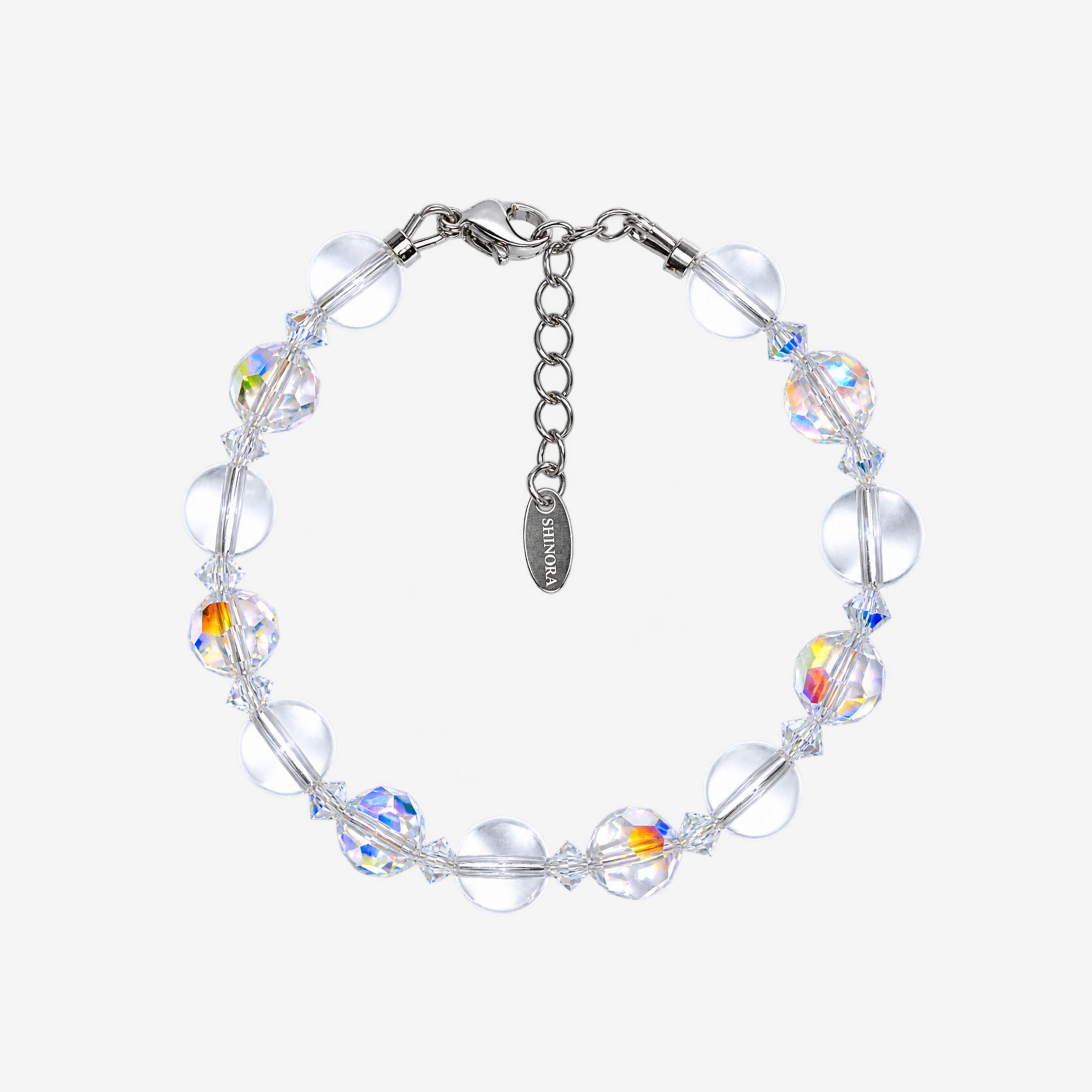 Bracelet with alternating smooth clear Swarovski beads and faceted iridescent crystals, clear spacers and a silver-tone clasp.