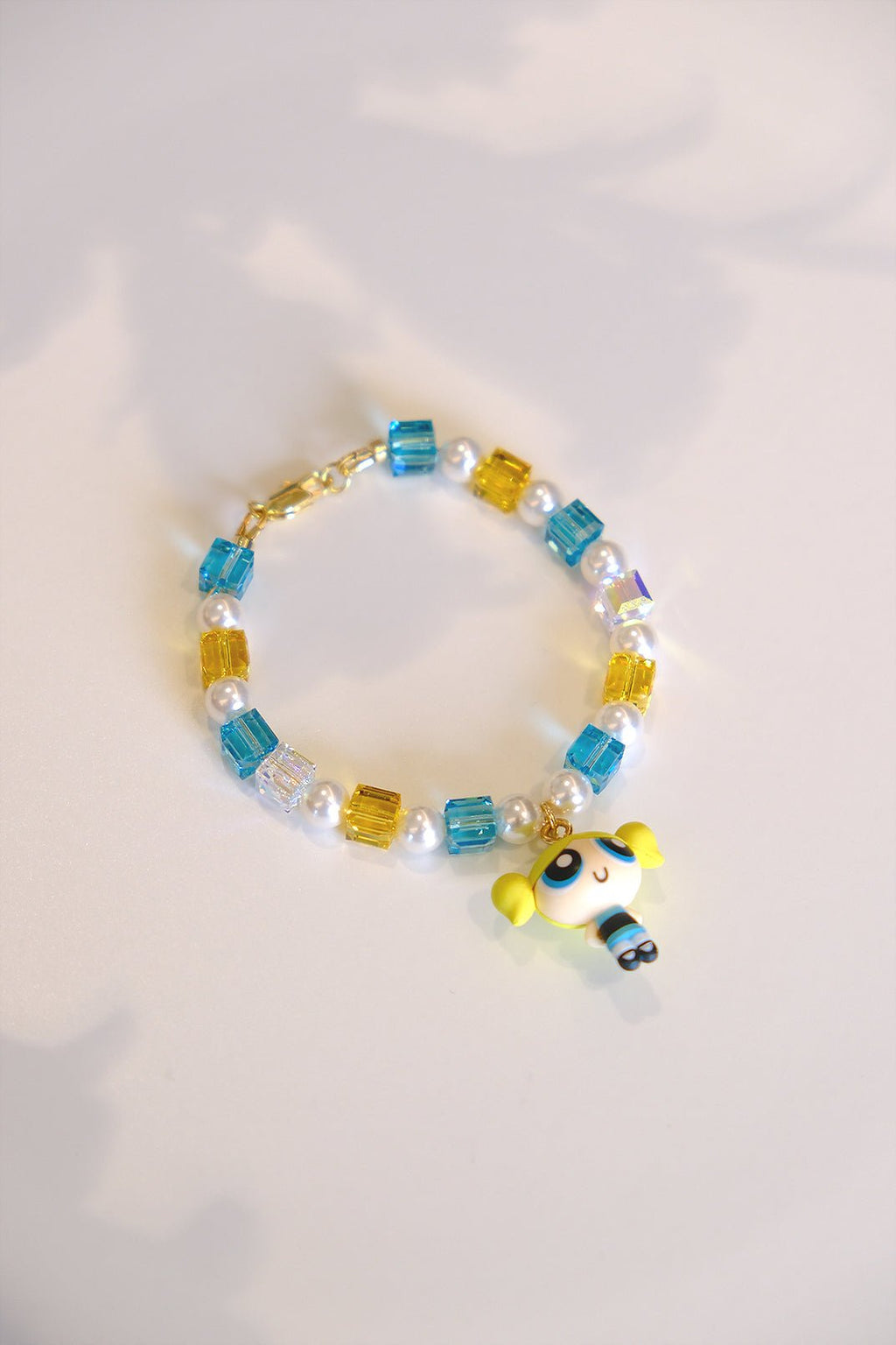 Close-up of vintage Bubbles Powerpuff Girls charm on handmade Swarovski crystal and pearl bracelet