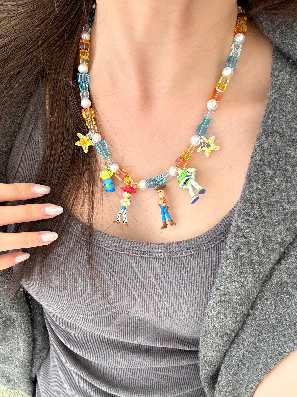 Close view of model wearing Y2K Swarovski charm necklace with vintage Toy Story pendants