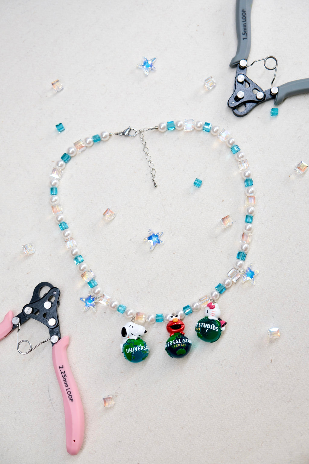 Close-up of three rare vintage charms on handmade Swarovski crystal and pearl necklace