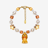 Golden Star Pup Charm Bracelet with amber faceted beads, cream pearl-style beads, gold stars and a brown dog charm.