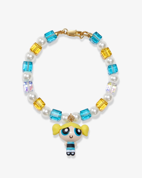 Flat lay of a handmade blue Swarovski crystal charm bracelet with crystals, pearls and nostalgic vintage-inspired collectible charm details