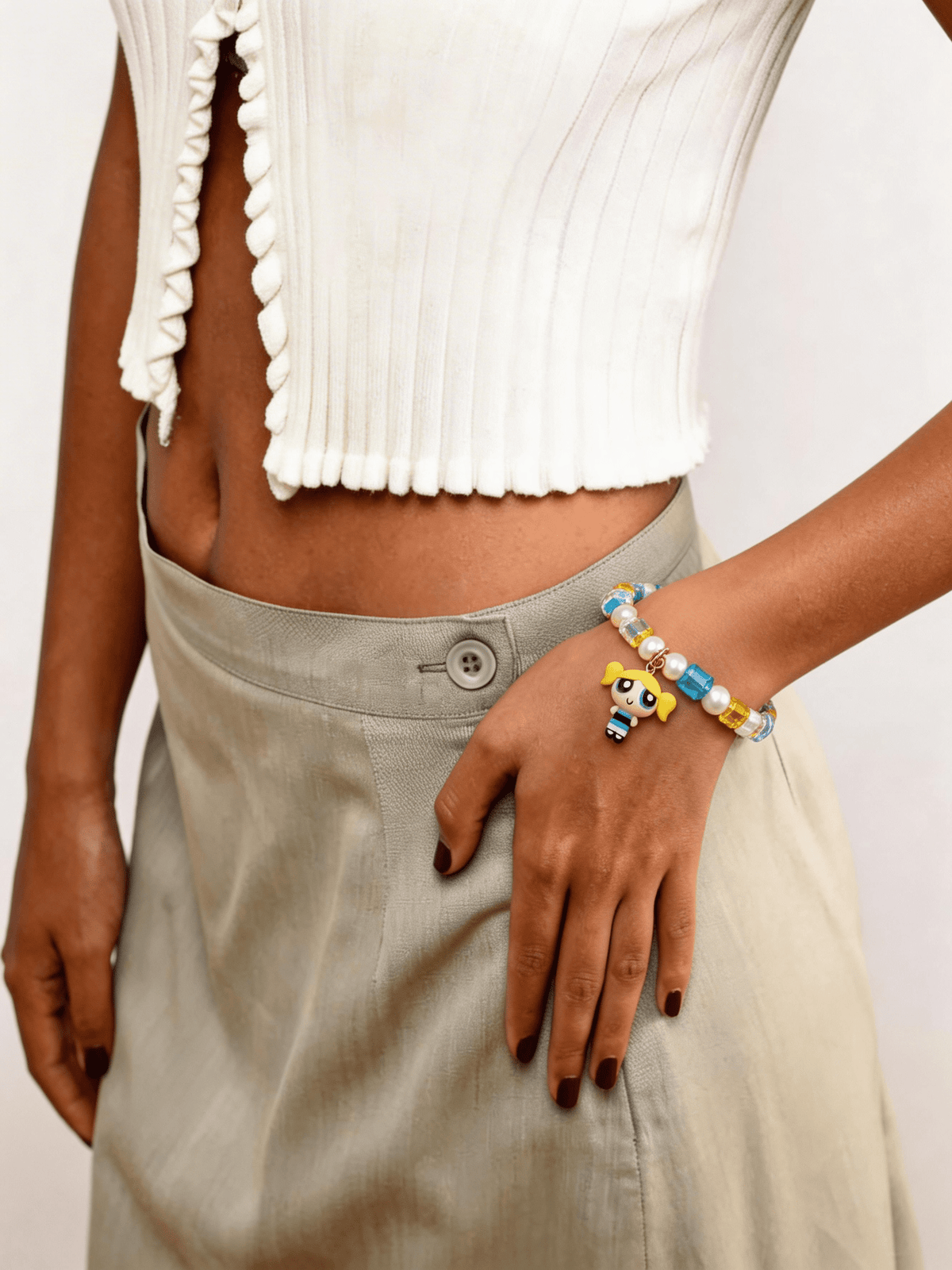 Model wearing a handmade blue Swarovski crystal charm bracelet with crystals, pearls and nostalgic vintage-inspired collectible charm details