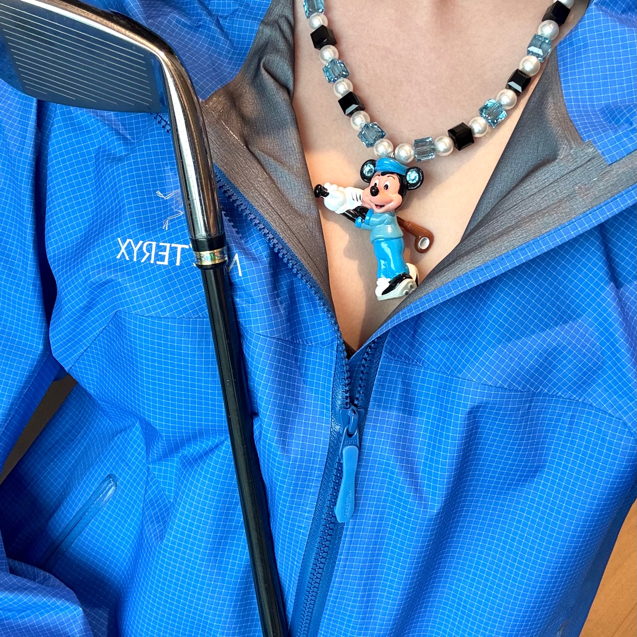 Close-up of a handmade blue Swarovski crystal charm necklace with crystals, pearls and sport-inspired collectible charm details