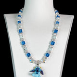 Close-up of a handmade blue Swarovski crystal charm necklace with crystals, pearls and cosmic-inspired collectible charm details