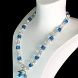 Model wearing a handmade blue Swarovski crystal charm necklace with crystals, pearls and cosmic-inspired collectible charm details
