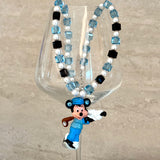 Model wearing a handmade blue Swarovski crystal charm necklace with crystals, pearls and sport-inspired collectible charm details