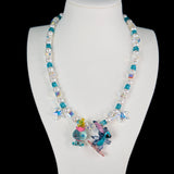 Close-up of a handmade blue Swarovski crystal charm necklace with crystals, pearls and surf-inspired collectible charm details