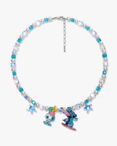 Flat lay of a handmade blue Swarovski crystal charm necklace with crystals, pearls and surf-inspired collectible charm details