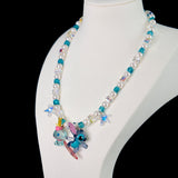 Model wearing a handmade blue Swarovski crystal charm necklace with crystals, pearls and surf-inspired collectible charm details
