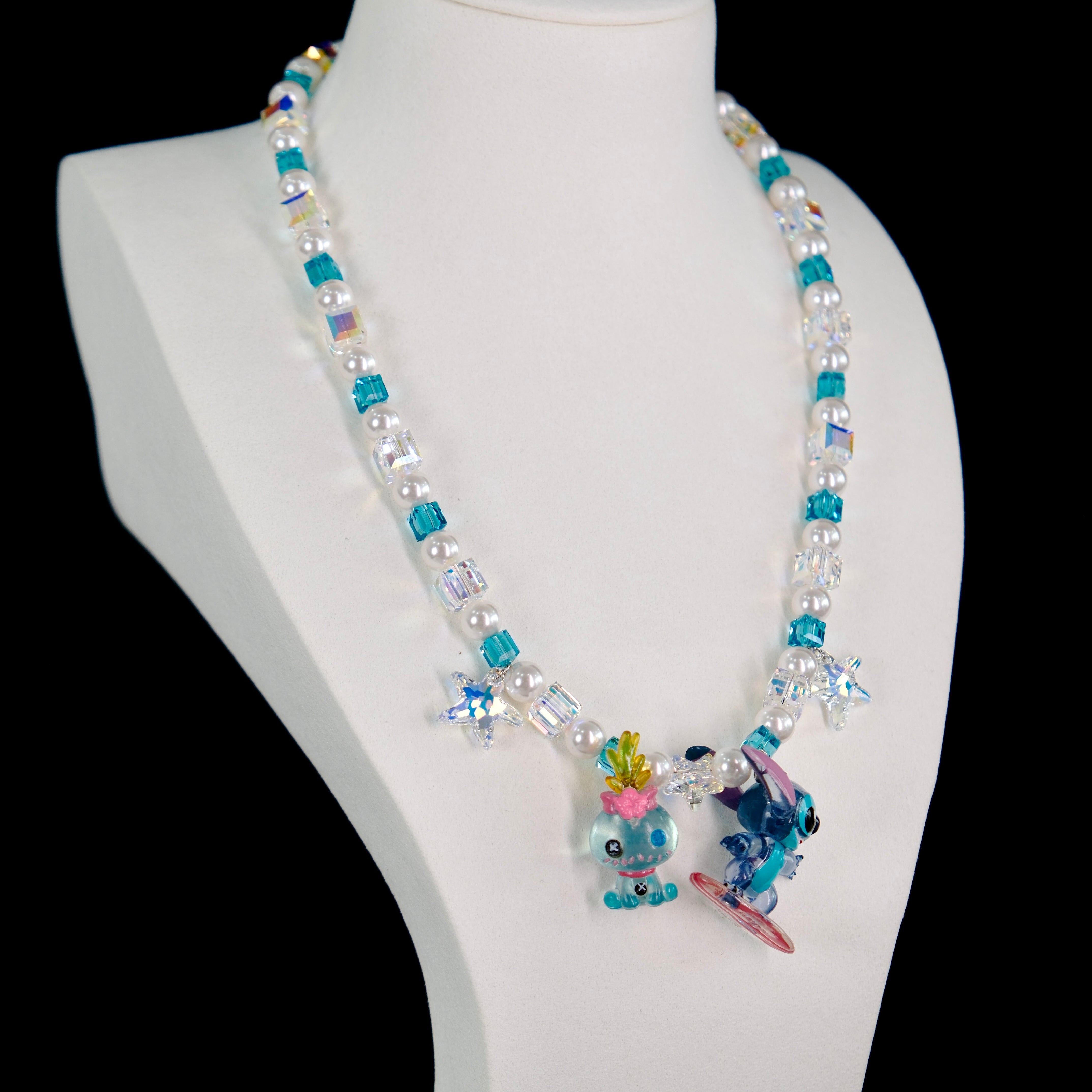 Side view of a handmade blue Swarovski crystal charm necklace with layered crystals, pearls and surf-inspired collectible charm details