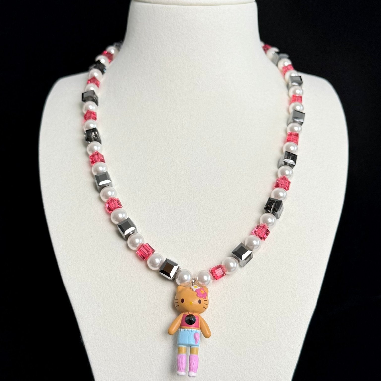 Model wearing a handmade dark Swarovski crystal charm necklace with crystals, pearls and city-inspired collectible charm details