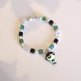 Close-up of a handmade green Swarovski crystal charm bracelet with crystals, pearls and nostalgic vintage-inspired collectible charm details