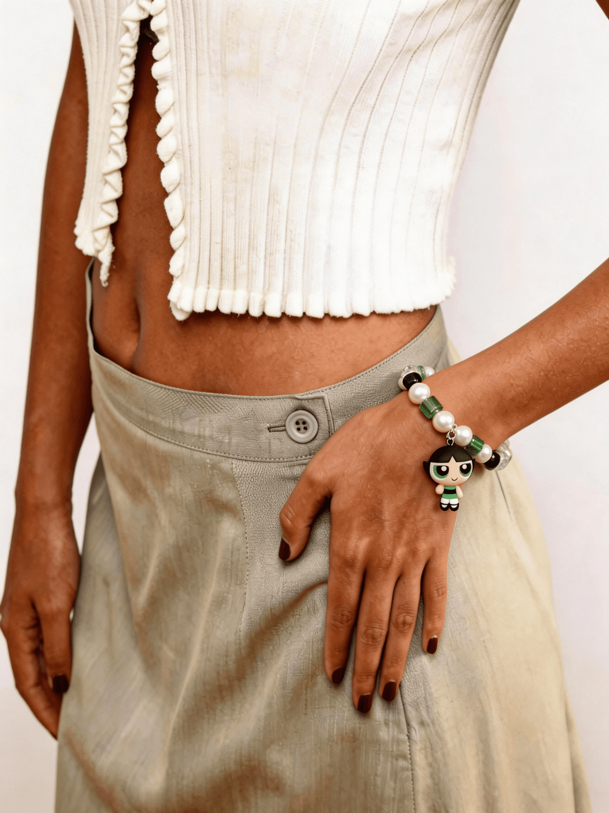 Model wearing a handmade green Swarovski crystal charm bracelet with crystals, pearls and nostalgic vintage-inspired collectible charm details