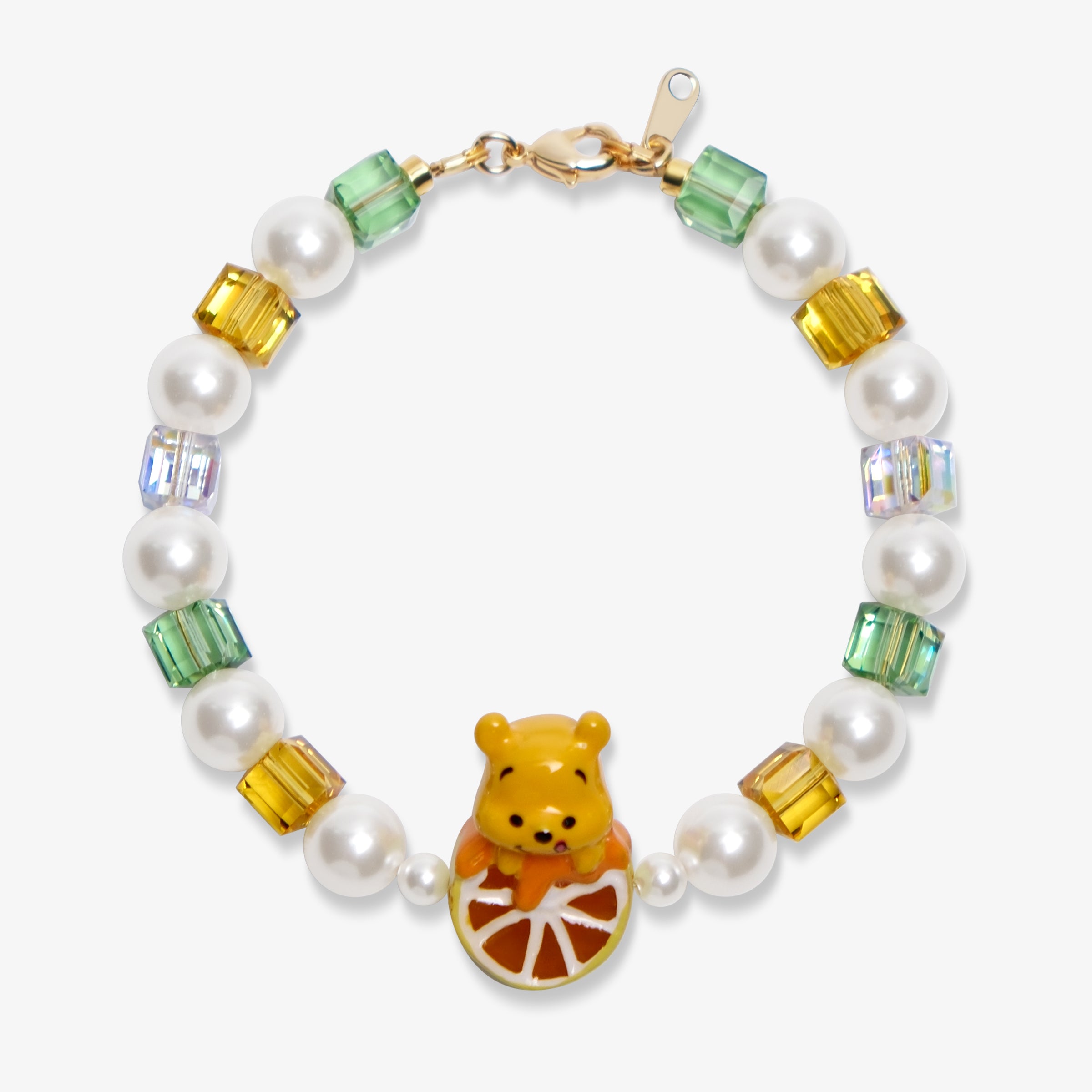Flat lay of a handmade honey citrus Swarovski crystal charm bracelet with crystals, pearls and garden-inspired collectible charm details