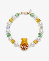 Flat lay of a handmade honey citrus Swarovski crystal charm bracelet with crystals, pearls and garden-inspired collectible charm details