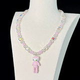 Close-up of a handmade iridescent Swarovski crystal charm necklace with crystals, pearls and sport-inspired collectible charm details