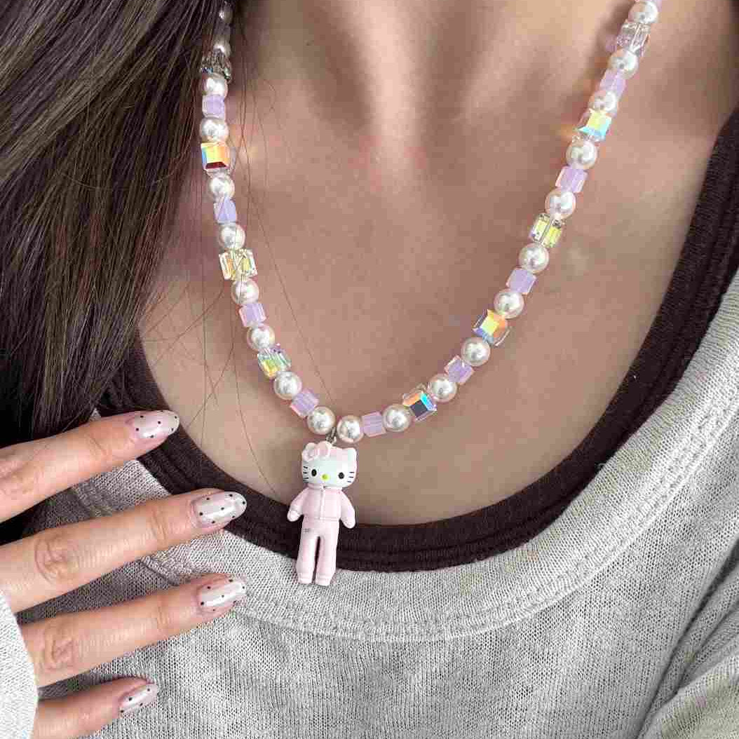 Close-up of a handmade iridescent Swarovski crystal charm necklace with crystals, pearls and sport-inspired collectible charm details