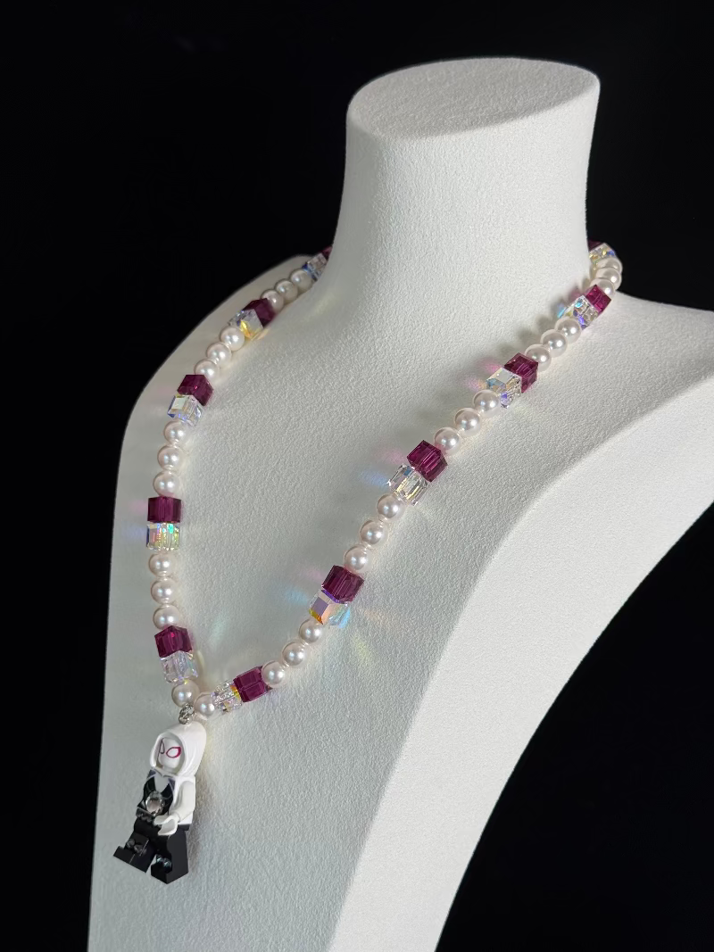 Close-up of a handmade pastel Swarovski crystal charm necklace with crystals, pearls and city-inspired collectible charm details