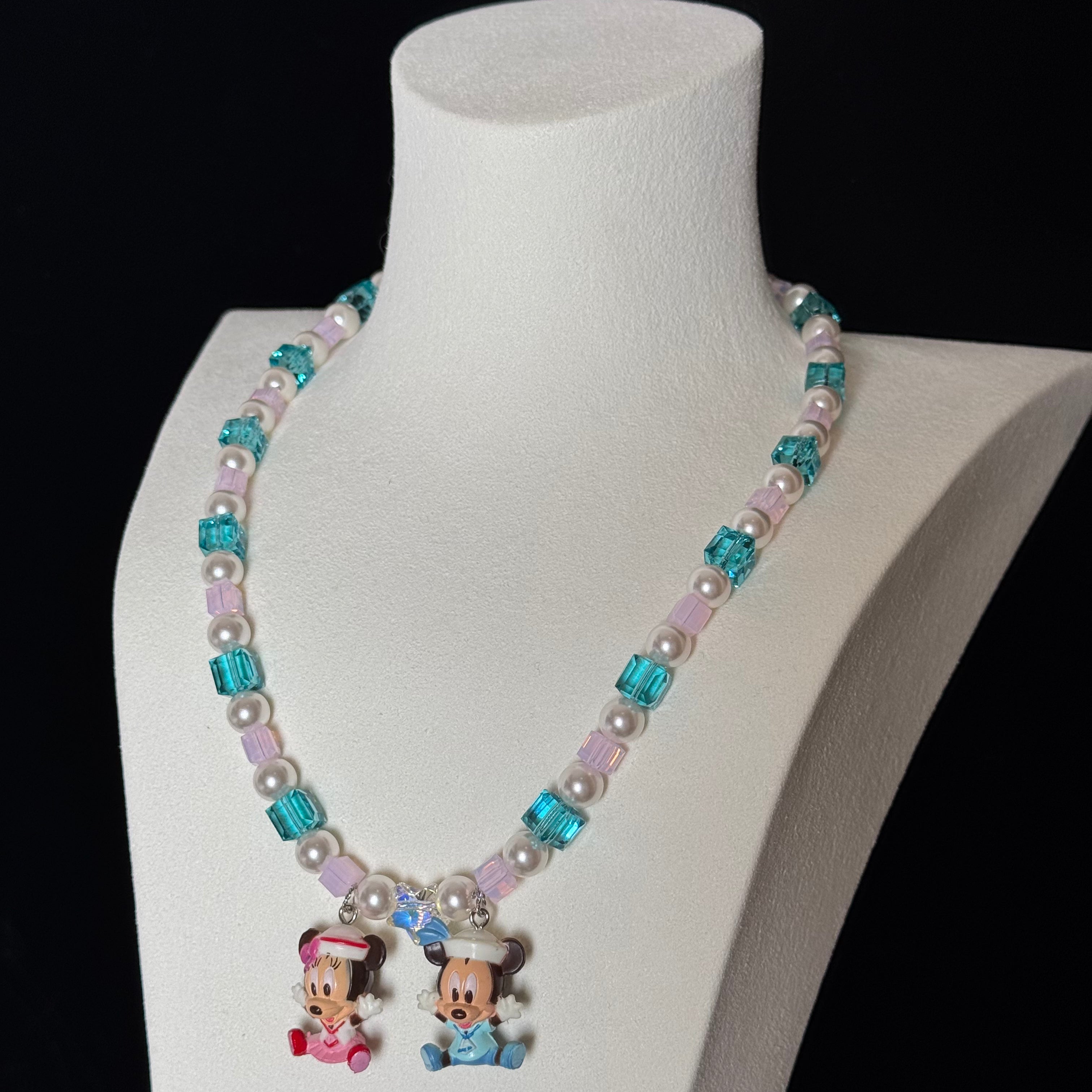 Close-up of a handmade pastel Swarovski crystal charm necklace with crystals, pearls and nostalgic vintage-inspired collectible charm details