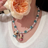 Close-up of a handmade pastel Swarovski crystal charm necklace with crystals, pearls and nostalgic vintage-inspired collectible charm details