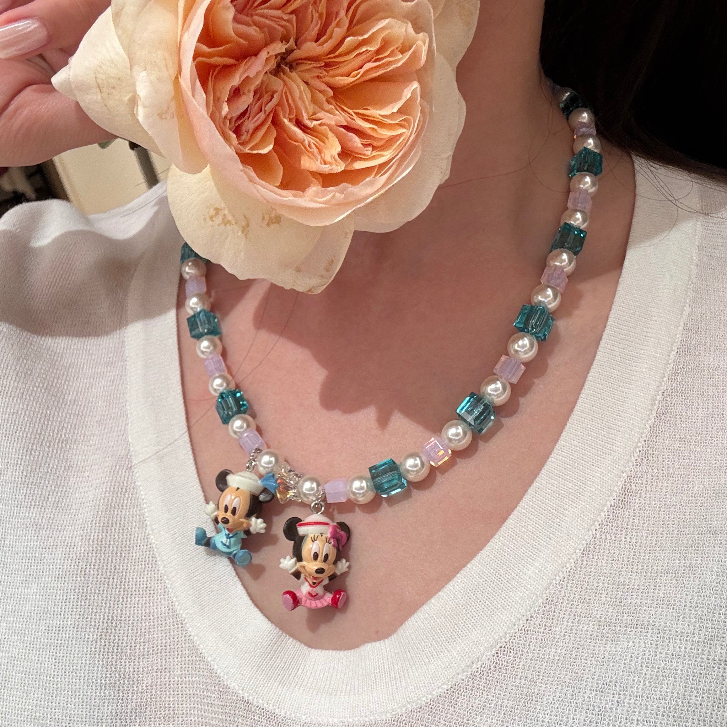 Close-up of a handmade pastel Swarovski crystal charm necklace with crystals, pearls and nostalgic vintage-inspired collectible charm details