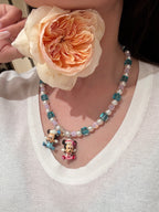 Close-up of a handmade pastel Swarovski crystal charm necklace with crystals, pearls and nostalgic vintage-inspired collectible charm details
