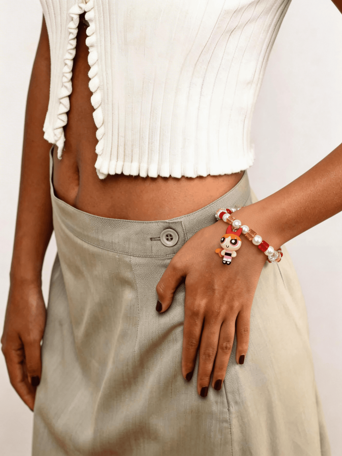 Model wearing a handmade pink Swarovski crystal charm bracelet with crystals, pearls and sweetheart-inspired collectible charm details