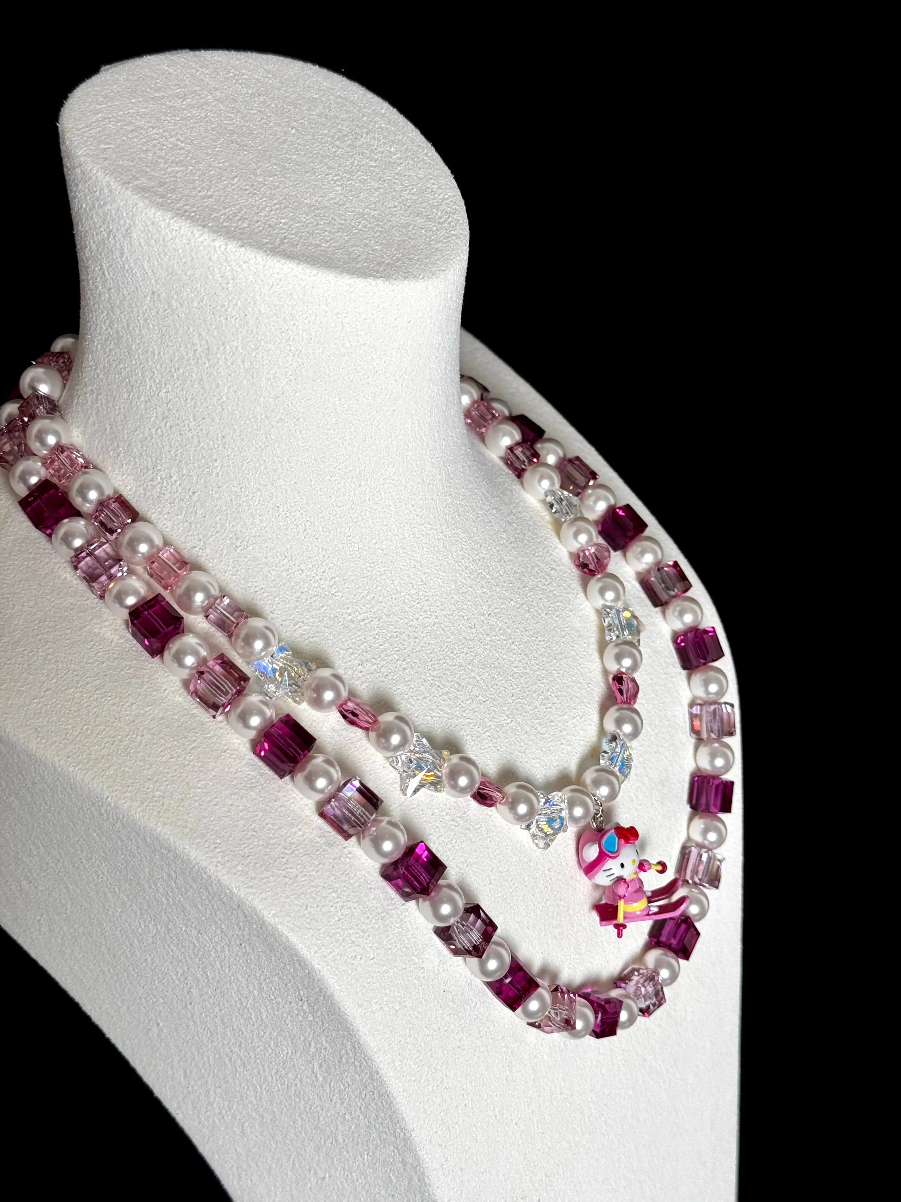 Close-up of a handmade pink Swarovski crystal charm necklace with crystals, pearls and ski-inspired collectible charm details