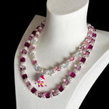 Model wearing a handmade pink Swarovski crystal charm necklace with crystals, pearls and ski-inspired collectible charm details