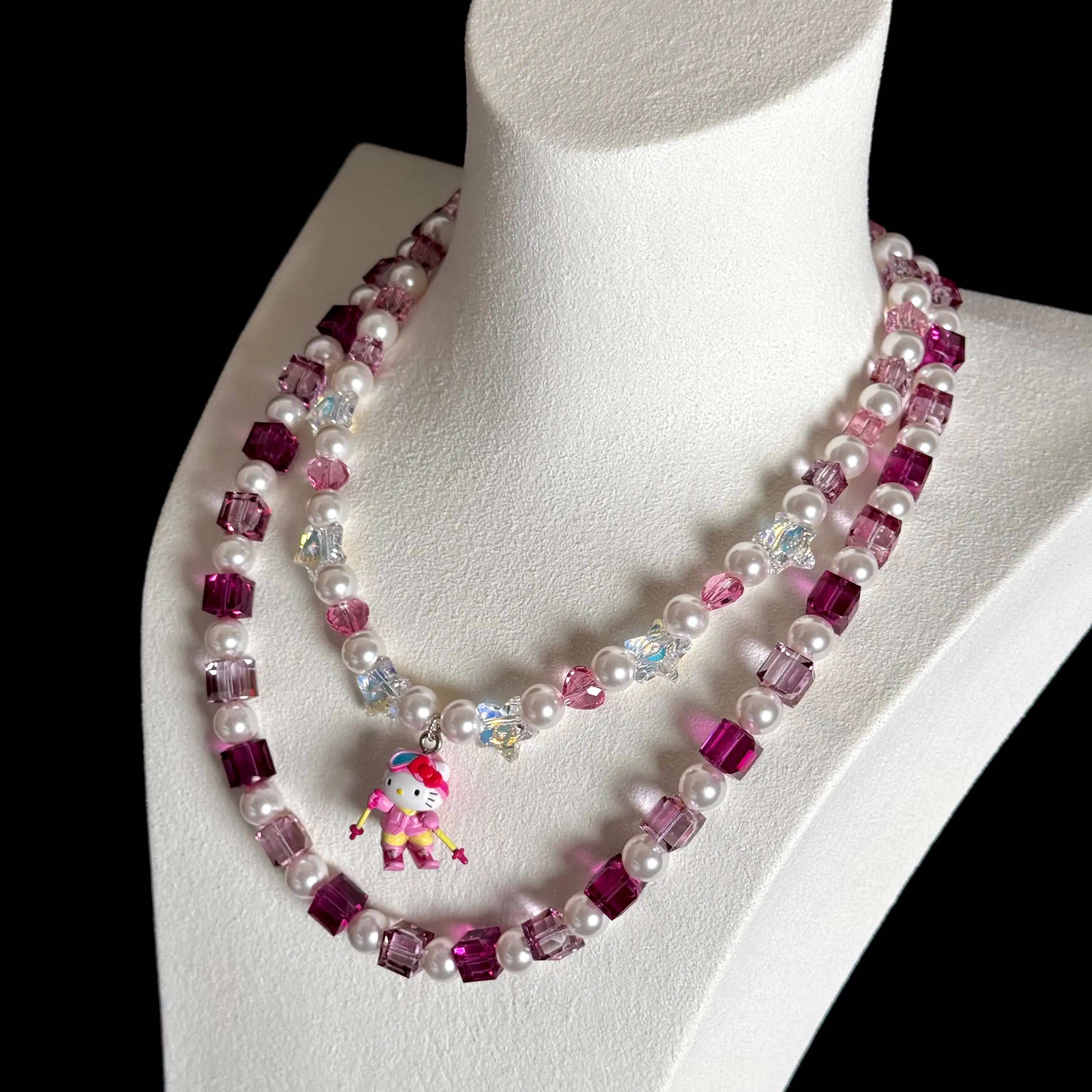 Model wearing a handmade pink Swarovski crystal charm necklace with crystals, pearls and ski-inspired collectible charm details
